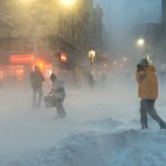 People walking in a snowy urban street during a blizzard