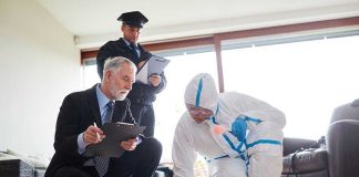 Forensic team examining evidence at a crime scene indoors.