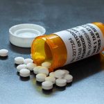 Trump Transparency Push Threatens Drug Giants Open pill bottle with white tablets spilled out.