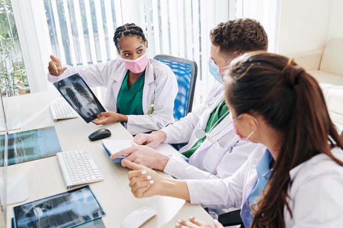 1779923279 Doctors discussing chest X-ray results at a workstation.