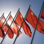 China UNLEASHES Radical Singles Campaign Red flags with yellow stars on flagpoles.