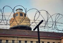 Cartel Gunmen STORM Prison Gates Barbed wire in front of a prison tower.