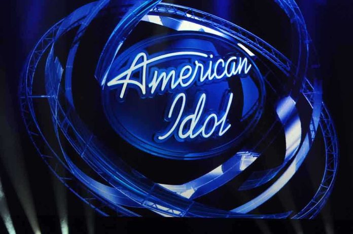 shutterstock_100780810.jpg American Idol logo illuminated in blue lights on stage