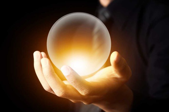 shutterstock_145689659.jpg A hand holding a glowing crystal ball against a dark background