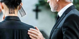 Man comforting woman at funeral service.
