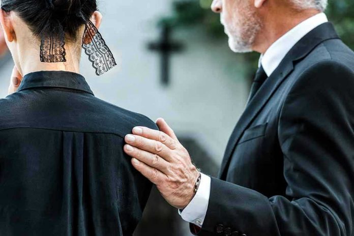 Man comforting woman at funeral service.