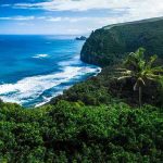 Beautiful coastal landscape with lush greenery and ocean waves.