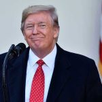 Predators Doubled: Trump’s Crackdown Erupts Man in suit and tie speaking at podium.