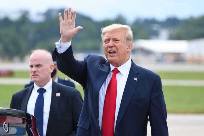 1821865589 Man in suit waving while another man stands nearby.