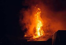 Building engulfed in large flames at night.