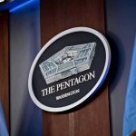 Pentagon Budget Bombshell Sparks Taxpayer Panic The Pentagon emblem between two flags.