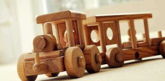 A wooden toy train set on a carpeted surface