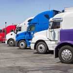 THOUSANDS of Truckers YANKED Off American Roads A lineup of colorful trucks parked in a lot