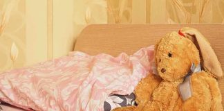 A cozy bedroom scene featuring a stuffed bunny and pink bedding