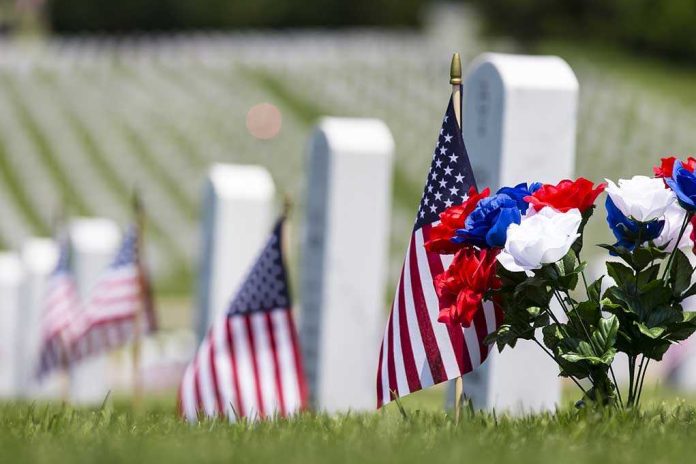 American flags and flowers placed at graves in a cemetery