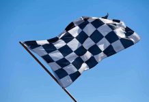 A checkered flag waving against a clear blue sky