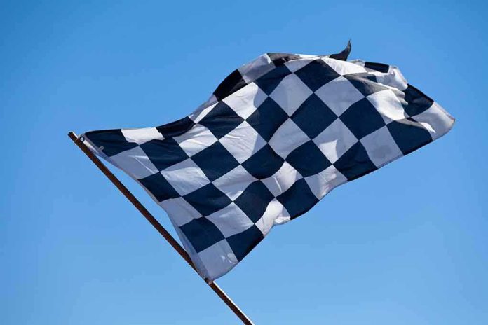 A checkered flag waving against a clear blue sky