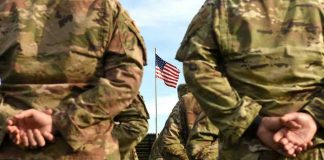 Delta Force LEAK EXPOSED — Army Insider Arrested Soldiers stand in formation with American flag in background.