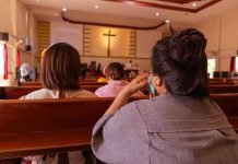 People sitting in church pews during service.