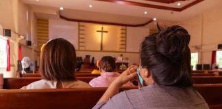 People sitting in church pews during service.