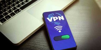 Smartphone displaying VPN app beside a laptop.