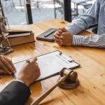 Two people discussing legal documents at a table.