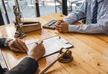 Two people discussing legal documents at a table.