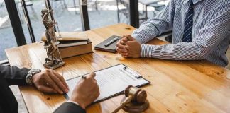 Tiger King’s Lawyer BUSTED — AI Fakery Exposed Two people discussing legal documents at a table.