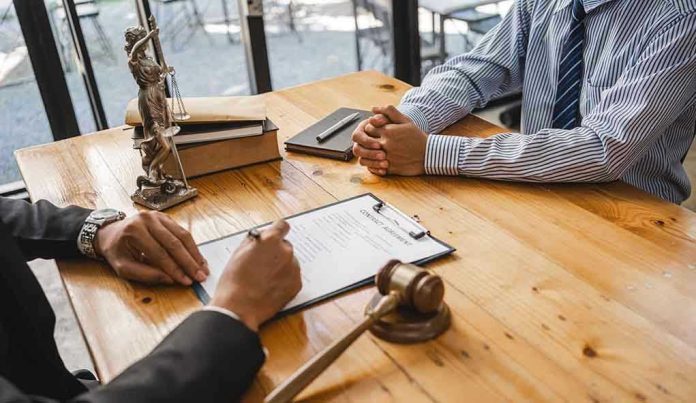 Two people discussing legal documents at a table.