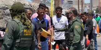 $145M ICE Buy Sparks Taxpayer FURY Border patrol agents inspecting group of individuals in line.