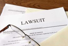 Documents labeled Lawsuit with glasses on top.