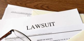 Documents labeled Lawsuit with glasses on top.