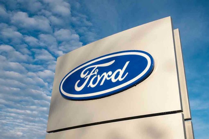 760679017 Ford logo sign against blue sky.