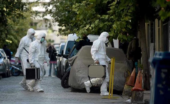 Investigators in hazmat suits carrying equipment cases.