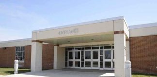 Entrance of a modern school building with glass doors and a brick facade
