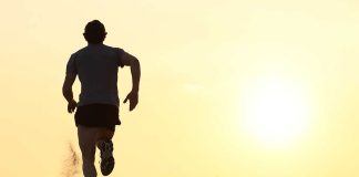 Silhouette of a man running on the beach during sunset