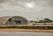 Aircraft hangar with helicopters near the beach.