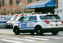 Police car and ambulances outside emergency room entrance.