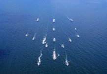 Aerial view of multiple naval ships operating in the ocean