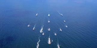 Aerial view of multiple naval ships operating in the ocean
