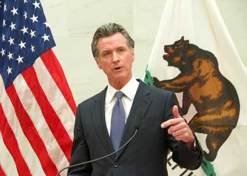 shutterstock_2150003241 A government official delivering a speech with flags in the background