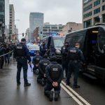 Police officers conducting an operation in an urban area with a crowd present