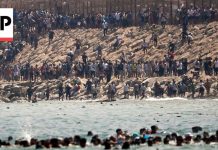 Thousands of migrants swim around the border from Morocco into Ceuta, Spain