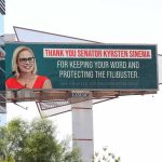 Communist Surge? White House Sounds Alarm Outdoor billboard with a smiling woman in glasses and red dress