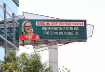 Outdoor billboard with a smiling woman in glasses and red dress