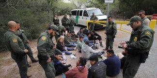 Conflict Warning: ICE Investigates ICE? Border agents surround a seated group near a van