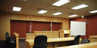 FBI Flags Noncitizen Ballots Interior view of an empty courtroom with wooden furniture and American flags