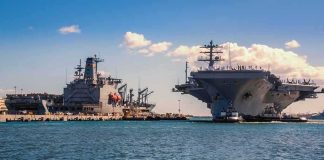 Pentagon Alarm: Destroyers Running Thin Aircraft carrier and support ships docked at a naval harbor