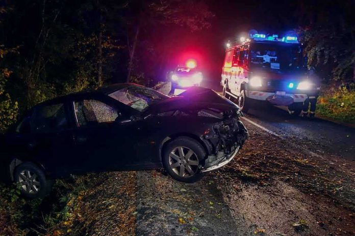 Crashed car on a dark roadside with emergency vehicles
