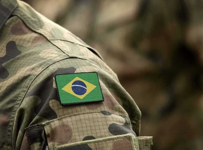 shutterstock_1522957613 Brazil flag patch on a camouflage military uniform sleeve